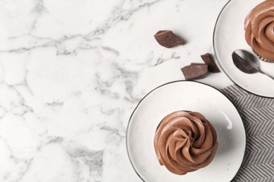 Delicious fresh chocolate cupcakes on white marble table, flat lay. Space for text