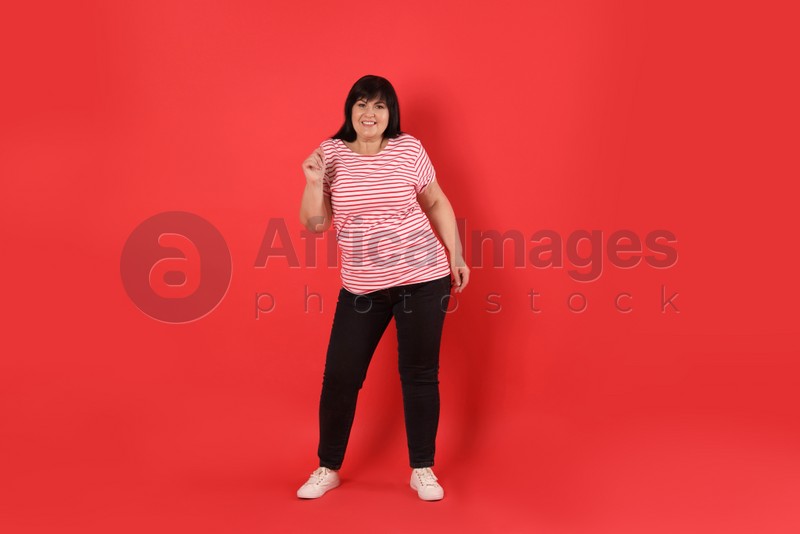 Beautiful overweight mature woman on red background