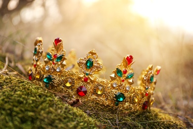 Beautiful golden crown on grass outdoors. Fantasy item