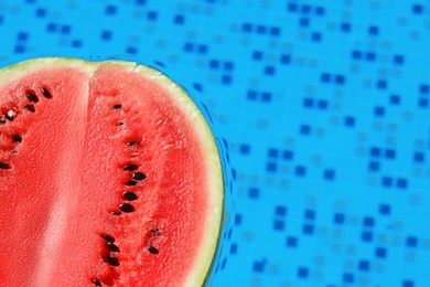 Photo of Half of fresh juicy watermelon in swimming pool, closeup. Space for text