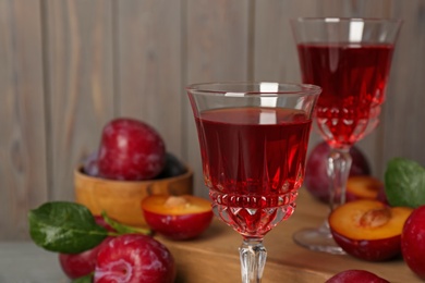 Delicious plum liquor on blurred background, closeup. Homemade strong alcoholic beverage