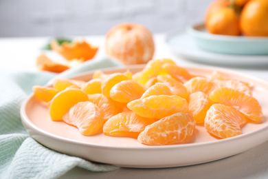 Segments of fresh ripe tangerines on white table, closeup