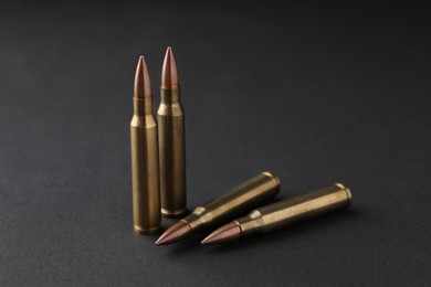 Many bullets on black background, closeup. Firearm ammunition