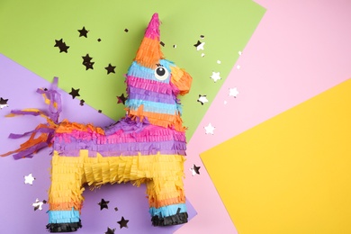 Photo of llama shaped pinata and glitter on color background, flat lay. Space for text