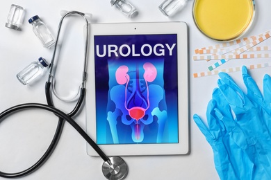 Flat lay composition with tablet, stethoscope and urine in dish on light background. Urology concept