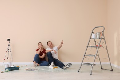 Happy couple discussing interior details in apartment during repair
