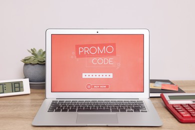 Laptop with activated promo code on wooden table indoors