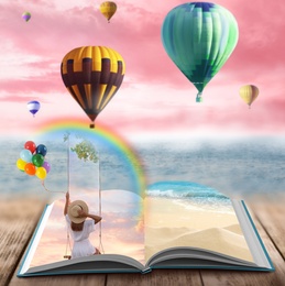 Fantasy worlds in fairytales. Book, hot air balloons and pink sky over misty sea on background
