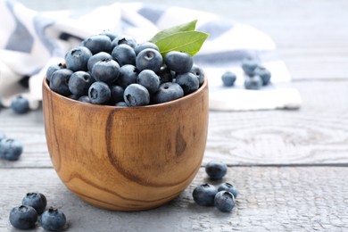 Tasty fresh blueberries on wooden table, closeup. Space for text