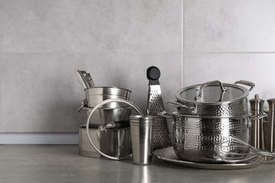 Set of different cooking utensils on grey countertop in kitchen