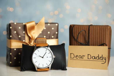 Composition with wristwatch and gift boxes on white table. Happy father's day