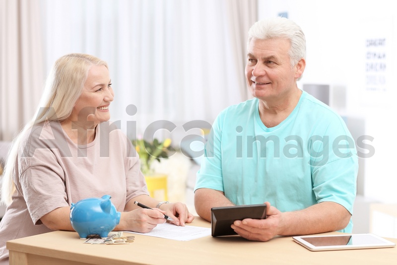 Mature couple thinking over pension payment at home