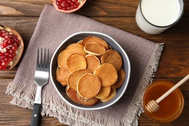 Delicious mini pancakes cereal served on wooden table, flat lay