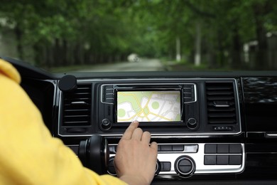 Woman using navigation system while driving car, closeup