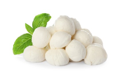 Pile of mozzarella cheese balls and basil on white background