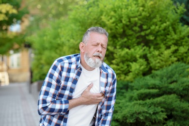 Mature man having heart attack, outdoors
