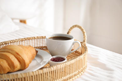 Tray with tasty breakfast on bed. Cozy morning