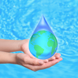 Woman holding icon of Earth in water drop on blue background, closeup. Ecology concept