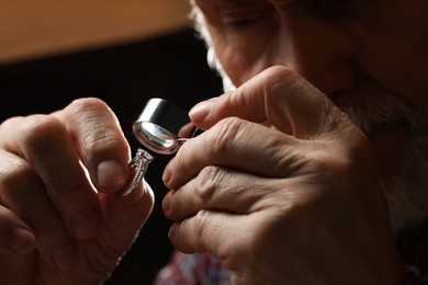 Photo of Professional jeweler working with ring, closeup view