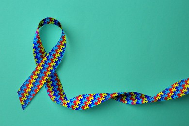 World Autism Awareness Day. Colorful puzzle ribbon on cyan background, top view