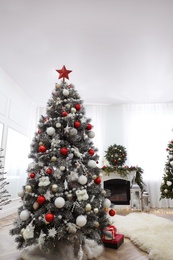 Beautiful Christmas tree with star topper in decorated room