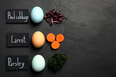 Photo of Naturally painted Easter eggs and space for text on black table, flat lay. Red cabbage, carrot, parsley used for coloring