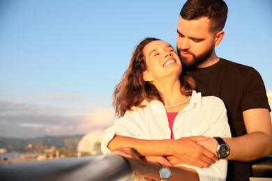 Happy young couple hugging on sea embankment