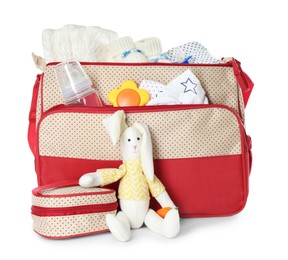 Maternity bag with child's clothes and accessories on white background