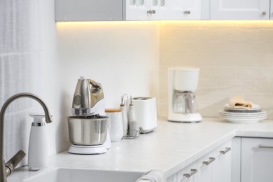 Photo of Modern toaster and other cooking appliances on countertop in kitchen
