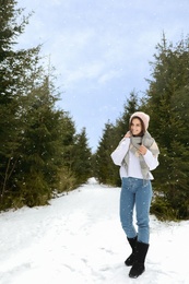 Young woman in snowy conifer forest. Winter vacation