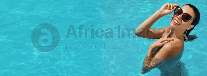 Beautiful woman wearing bikini in swimming pool, space for text. Banner design