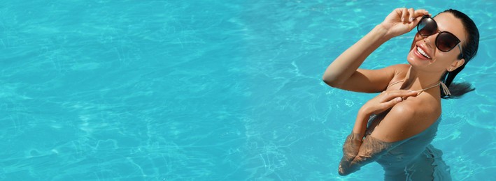 Beautiful woman wearing bikini in swimming pool, space for text. Banner design