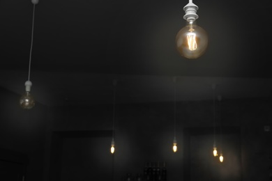 Lamp bulbs in dark room. Space for text