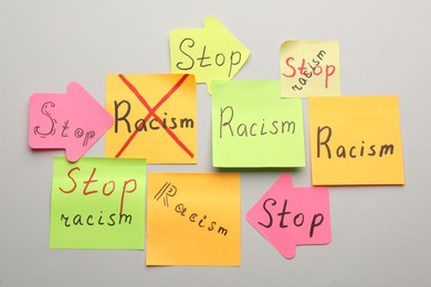 Paper notes with phrase Stop Racism on light background, flat lay
