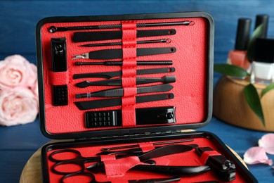 Photo of Manicure set in case on blue table, closeup