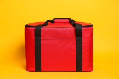 Modern red thermo bag on yellow background