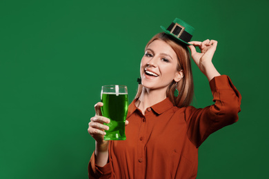Young woman with green beer on color background. St. Patrick's Day celebration