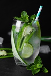 Photo of Spicy cocktail with jalapeno, cucumber, lime and mint on black table