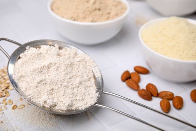 Different types of flour on tiled table, closeup