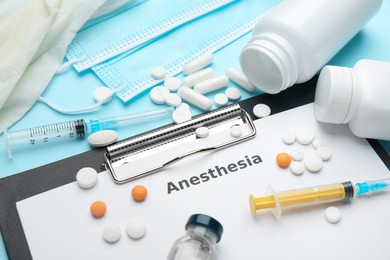 Composition of clipboard with word Anesthesia and drugs on light blue background, closeup