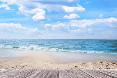 Empty wooden surface near sandy beach and sea on sunny day