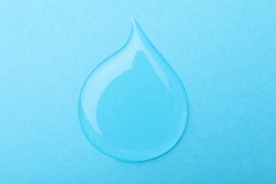 Photo of Drop on light blue background, top view. Save water concept