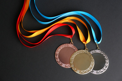 Gold, silver and bronze medals on black background, flat lay. Space for design