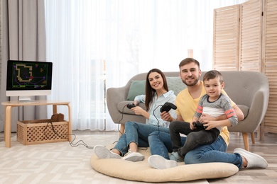 Happy family playing video games at home. Space for text