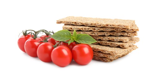 Crunchy rye crispbreads, fresh cherry tomatoes and basil on white background