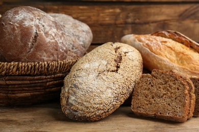 Different kinds of fresh bread on wooden table