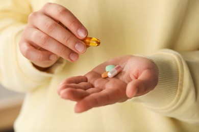 Photo of Young woman with dietary supplement pills, closeup