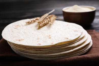 Stack of tasty tortillas on fabric, closeup