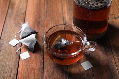 Photo of Tea bag in glass cup on wooden table