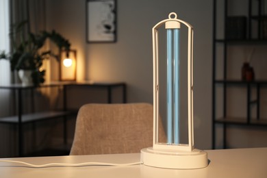 UV sterilizer lamp on table at home. Space for text